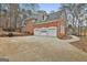 Exterior view of home with a three-car garage, set against a backdrop of mature trees at 165 Standing Oak Pl, Fayetteville, GA 30214