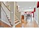 Open hallway with staircase, hardwood floors, and a view into the kitchen and dining area at 165 Standing Oak Pl, Fayetteville, GA 30214