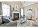 Comfortable living room with a fireplace, hardwood floors, and large windows for plenty of natural light at 165 Standing Oak Pl, Fayetteville, GA 30214