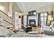 Relaxing living room features a fireplace, large windows, and stairs leading to the second floor at 165 Standing Oak Pl, Fayetteville, GA 30214