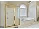A bright bathroom featuring a separate shower and tub with natural light from the window at 165 Standing Oak Pl, Fayetteville, GA 30214