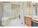 A spacious main bathroom with a tub, dual vanity, and private water closet at 165 Standing Oak Pl, Fayetteville, GA 30214
