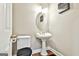 This half-bath offers a pedestal sink, framed mirror and decor; perfect for guests at 165 Standing Oak Pl, Fayetteville, GA 30214