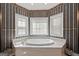 Elegant bathroom features a garden tub, garden window, and natural light at 7395 Old Rico Rd., Chattahoochee Hills, GA 30268