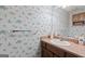 A cozy half-bath features patterned wallpaper and a pedestal sink at 7395 Old Rico Rd., Chattahoochee Hills, GA 30268