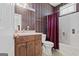 Bathroom featuring a shower, toilet, sink, and striped wallpaper with floral accents at 7395 Old Rico Rd., Chattahoochee Hills, GA 30268
