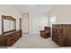 Neutral carpeted bedroom with a comfortable armchair and a large dresser featuring a mirror at 7395 Old Rico Rd., Chattahoochee Hills, GA 30268
