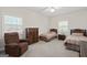 Neutral carpeted bedroom featuring two twin beds, a dresser, and a comfortable armchair at 7395 Old Rico Rd., Chattahoochee Hills, GA 30268