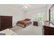 Bedroom featuring neutral colored walls, carpet flooring, and a cozy bed with an elegant lamp at 7395 Old Rico Rd., Chattahoochee Hills, GA 30268