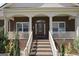 Close-up of a brick home's front porch featuring columns and brick stairs at 7395 Old Rico Rd., Chattahoochee Hills, GA 30268