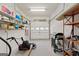 A well-organized garage with storage shelves, a grill, and a lawnmower at 7395 Old Rico Rd., Chattahoochee Hills, GA 30268