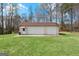 View of the detached garage with three bays and adjacent yard for outdoor activities at 7395 Old Rico Rd., Chattahoochee Hills, GA 30268