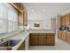 Well-equipped kitchen with wooden cabinets, stainless steel sink, and views into an adjacent eating area at 7395 Old Rico Rd., Chattahoochee Hills, GA 30268