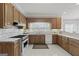 Functional kitchen featuring white countertops, wooden cabinets, and updated appliances for meal preparation at 7395 Old Rico Rd., Chattahoochee Hills, GA 30268