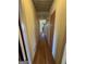 Long hallway with wood flooring, wall mounted lights, and access to rooms at 2518 Caladium Ne Dr, Atlanta, GA 30345