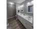 Bathroom featuring double sink vanity with modern fixtures and laminate floor at 1105 Bradford Park Dr, Auburn, GA 30011