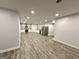 Spacious basement kitchen with white cabinets, stainless steel appliances, and wood-look floors at 1521 Ashbury Park Dr, Hoschton, GA 30548