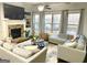 Spacious living room featuring a fireplace, large windows, and comfortable sofas at 1521 Ashbury Park Dr, Hoschton, GA 30548