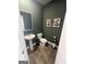 Stylish powder room with dark green walls, wood-look floors, and pedestal sink at 11551 Kimberly Way # 17, Hampton, GA 30228