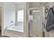 Luxurious bathroom featuring a soaking tub, a glass-enclosed shower, and modern fixtures, offering a spa-like experience at 130 Brooks Cir, Hampton, GA 30228