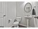 Cozy half bathroom showcases an elegant pedestal sink, a decorative mirror, and modern fixtures at 130 Brooks Cir, Hampton, GA 30228