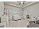 Cozy Bedroom with white crib, ceiling fan, floral curtains, and plush seating at 130 Brooks Cir, Hampton, GA 30228