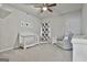 Bedroom featuring a ceiling fan, white crib, floral curtains, and plush seating at 130 Brooks Cir, Hampton, GA 30228