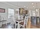 Bright dining room featuring a dark wood table with white chairs, and hardwood flooring throughout at 130 Brooks Cir, Hampton, GA 30228