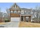 Charming two-story home with brick facade, white garage door and landscaped front yard at 130 Brooks Cir, Hampton, GA 30228