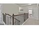 Bright hallway with carpeted floors and wooden railings offers a transition between floors and rooms at 130 Brooks Cir, Hampton, GA 30228