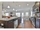 Gourmet kitchen with island, stainless appliances, and hardwood floors open to the living area at 130 Brooks Cir, Hampton, GA 30228