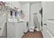 Functional laundry room with washer, dryer, and storage shelves for convenience at 130 Brooks Cir, Hampton, GA 30228