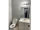Bathroom featuring white vanity and toilet, mirror, and gray walls at 4477 Golf Vista Cir, Decatur, GA 30035