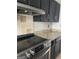 Close-up of a kitchen featuring stainless steel appliances, dark cabinets, and granite countertops at 4477 Golf Vista Cir, Decatur, GA 30035