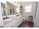 Bright bathroom featuring double vanity, a large mirror, and wood flooring at 31 Pecan Lake Ct, Sharpsburg, GA 30277