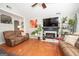 Comfortable living room with hardwood floors, a ceiling fan, and a cozy fireplace at 31 Pecan Lake Ct, Sharpsburg, GA 30277