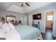 Comfortable main bedroom featuring tray ceilings, wood floors, and ensuite bathroom access at 31 Pecan Lake Ct, Sharpsburg, GA 30277