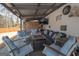 Inviting covered patio featuring comfortable seating, a cozy fire pit, and a mounted TV for outdoor entertainment at 31 Pecan Lake Ct, Sharpsburg, GA 30277