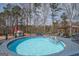 A beautiful swimming pool surrounded by a wooden deck and tall trees at 31 Pecan Lake Ct, Sharpsburg, GA 30277