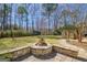 Stone paver patio with a fire pit and manicured landscaping at 339 Kensington Dr, Peachtree City, GA 30269