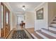 Warm and welcoming foyer with hardwood floors, staircase, and views into the dining area with a decorative rug at 339 Kensington Dr, Peachtree City, GA 30269