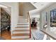 Bright foyer with staircase, hardwood floors, and view to living area and outdoor patio at 339 Kensington Dr, Peachtree City, GA 30269