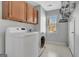 Laundry room with a washer, a dryer, wooden cabinets, and bright window at 339 Kensington Dr, Peachtree City, GA 30269