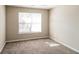 An empty, carpeted bedroom with neutral walls and a large window at 5345 Bridle Point Pkwy, Snellville, GA 30039