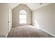 A large, carpeted bedroom with a vaulted ceiling and a large arched window letting in lots of light at 5345 Bridle Point Pkwy, Snellville, GA 30039