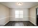 An empty dining room with gray-washed wood flooring and a large window at 5345 Bridle Point Pkwy, Snellville, GA 30039