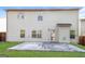 Home exterior featuring a backyard, a concrete patio, a grassy yard, and tan siding at 7569 Bowhead Ct, Fairburn, GA 30213