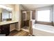 Bright bathroom featuring a soaking tub, tiled shower, vanity with double sinks, and updated fixtures at 7569 Bowhead Ct, Fairburn, GA 30213