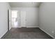 Bedroom featuring neutral gray walls, plush gray carpet, bright light, and an open doorway at 7569 Bowhead Ct, Fairburn, GA 30213