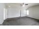 Open layout bedroom with gray carpet, fan, and multiple white doors and natural lighting illuminating the space at 7569 Bowhead Ct, Fairburn, GA 30213